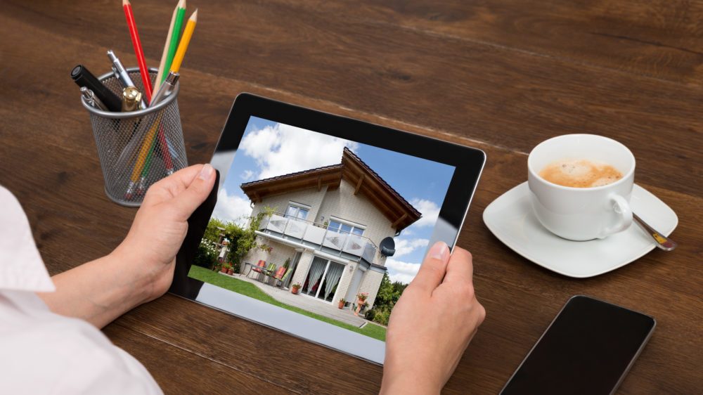 Home Buyer Looking At House Photo On Digital Tablet with Top-Quality Photos