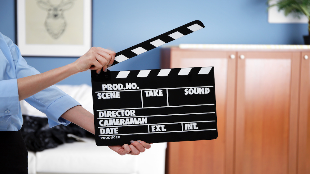Woman hands holding film clapper, close up in movie location rental.