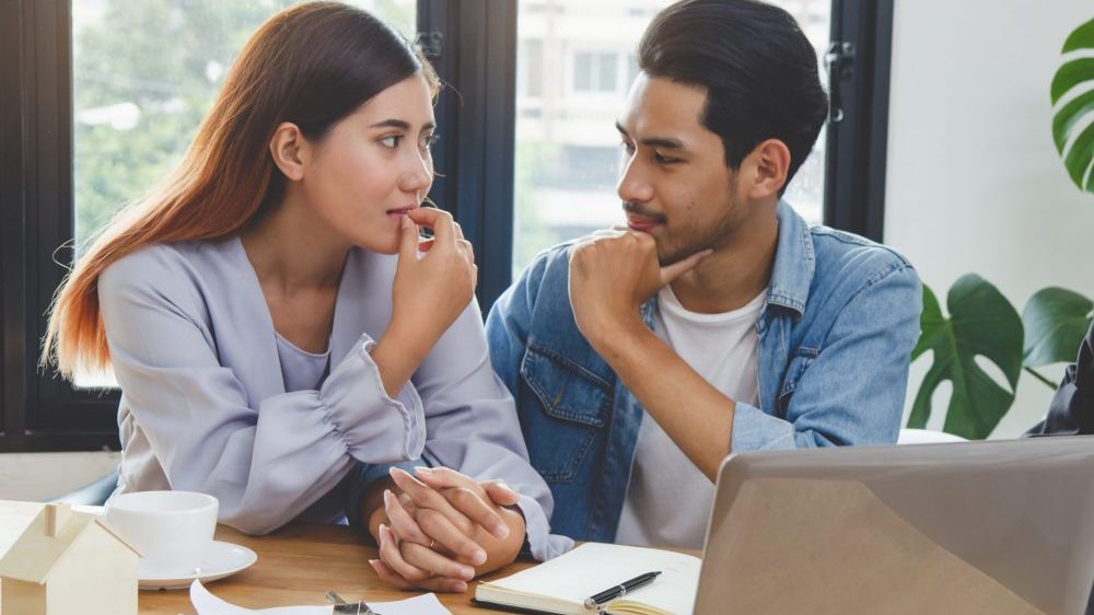 New home buyer couple showing the concept of discussing the subject of financing your first home.