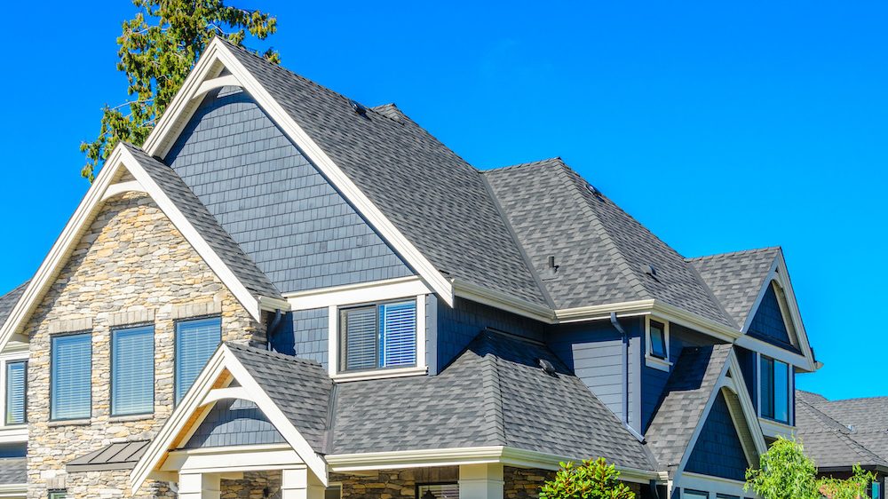 The roof of the house with nice windows against a blue sky.