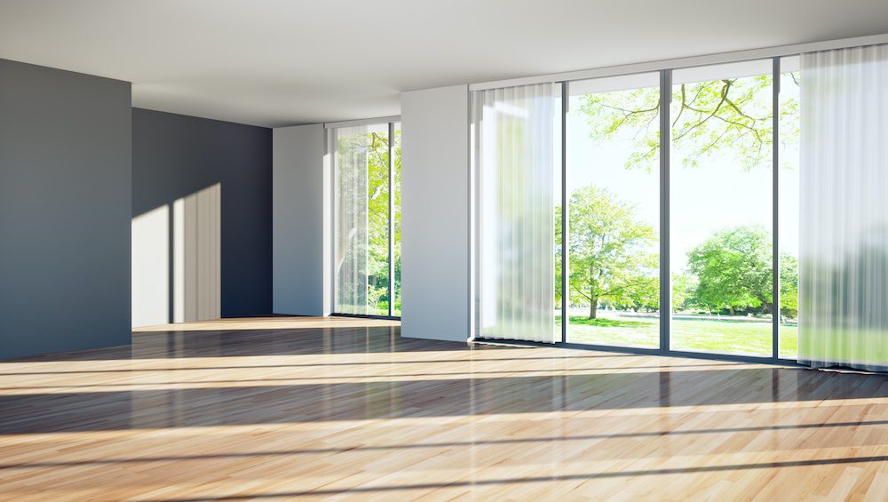 Vacant home living room with floor to ceiling windows.