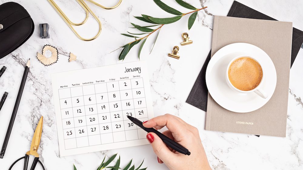 Desktop with calendar for January and office supplies. Home office, social media blog, schedule, planning concept.