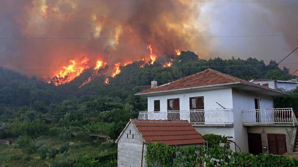 Massive wildfire burning down the forest and wildfire smoke threatens the indoor air quality for homeowners in the area.