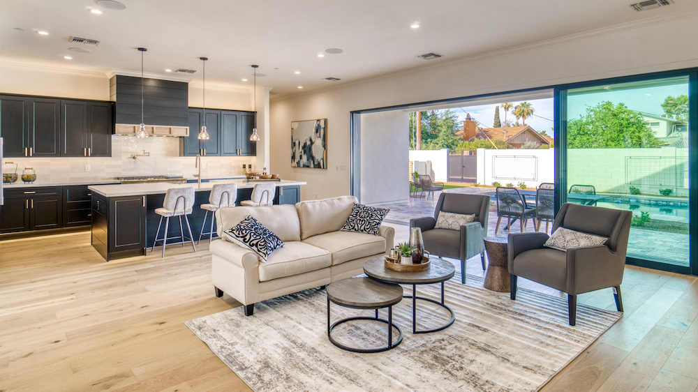 Large open floor plan with kitchen, living room and patio that shows a post-panndemic home design.