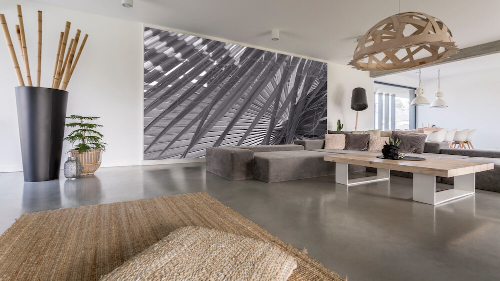 Decorative chandelier above designed table in living room with a grey wallpaper mural on wall